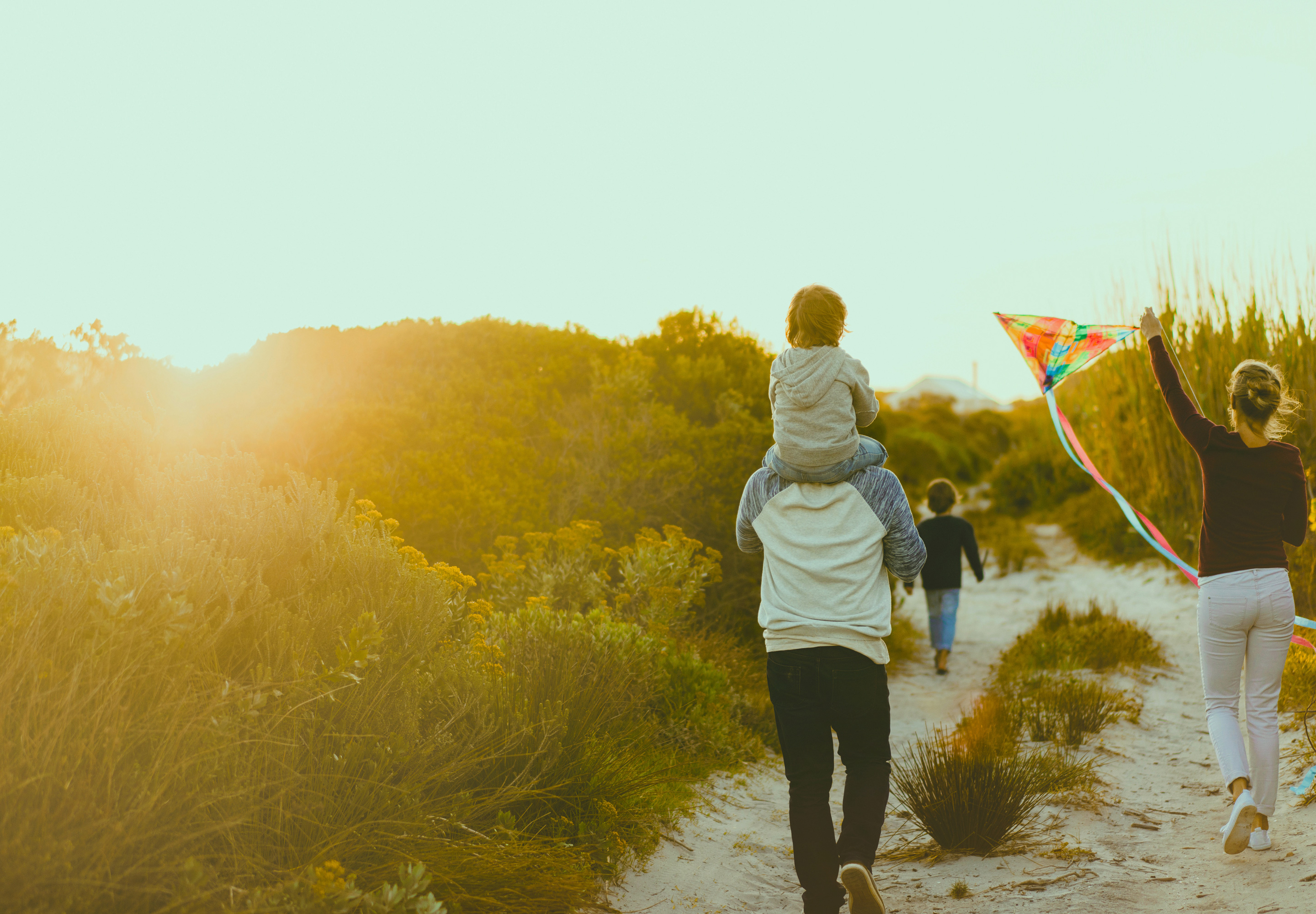 young family walking on sandy path